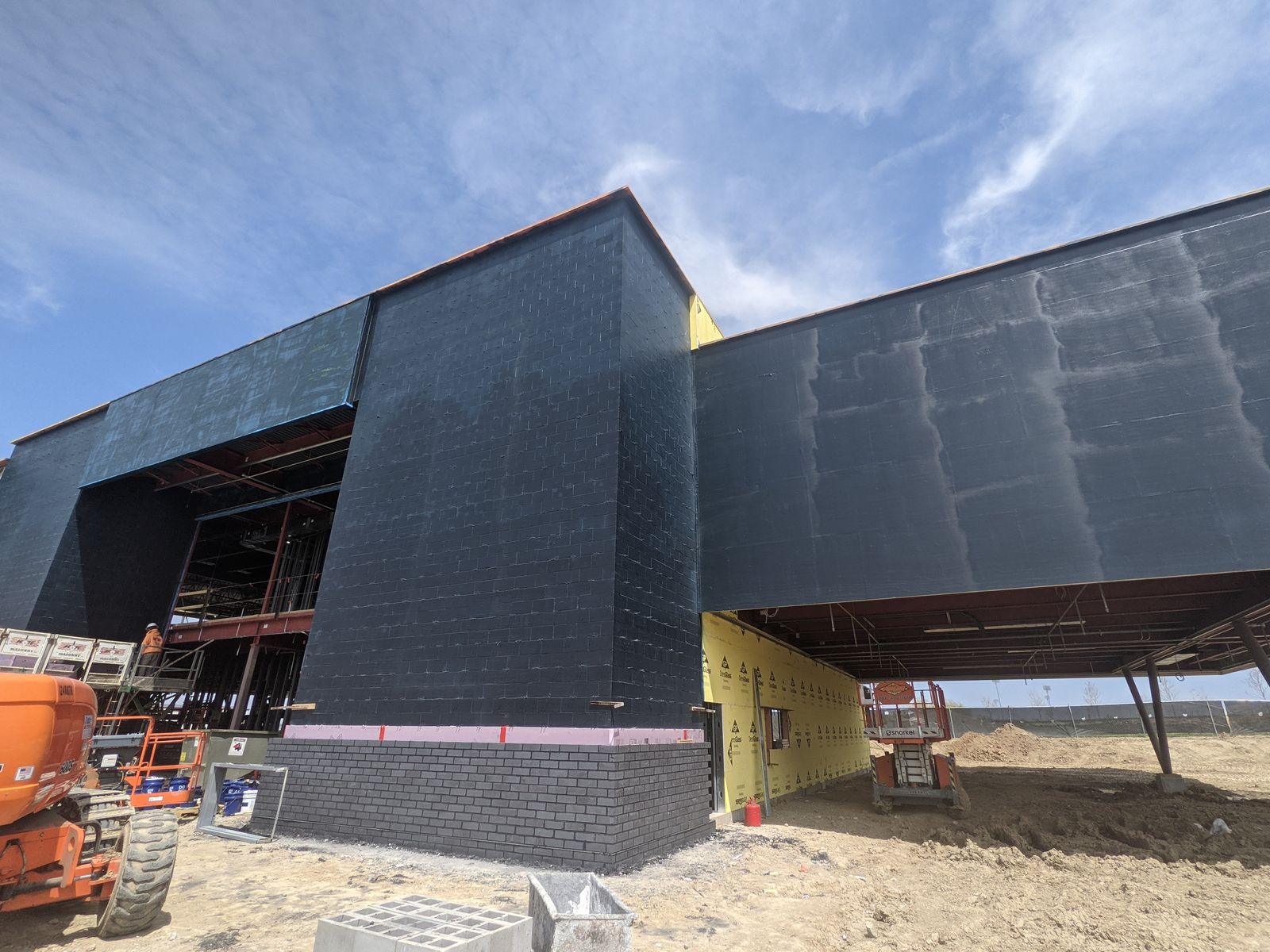 Fluid-applied air barrier installed on an exterior wall ahead of cladding