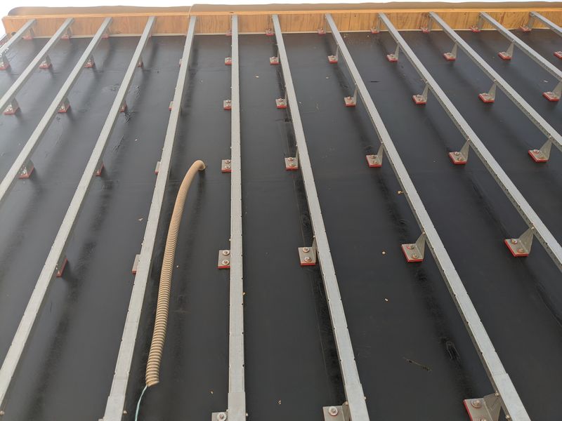 Cladding attachment — vertical sub-framing set over the air barrier