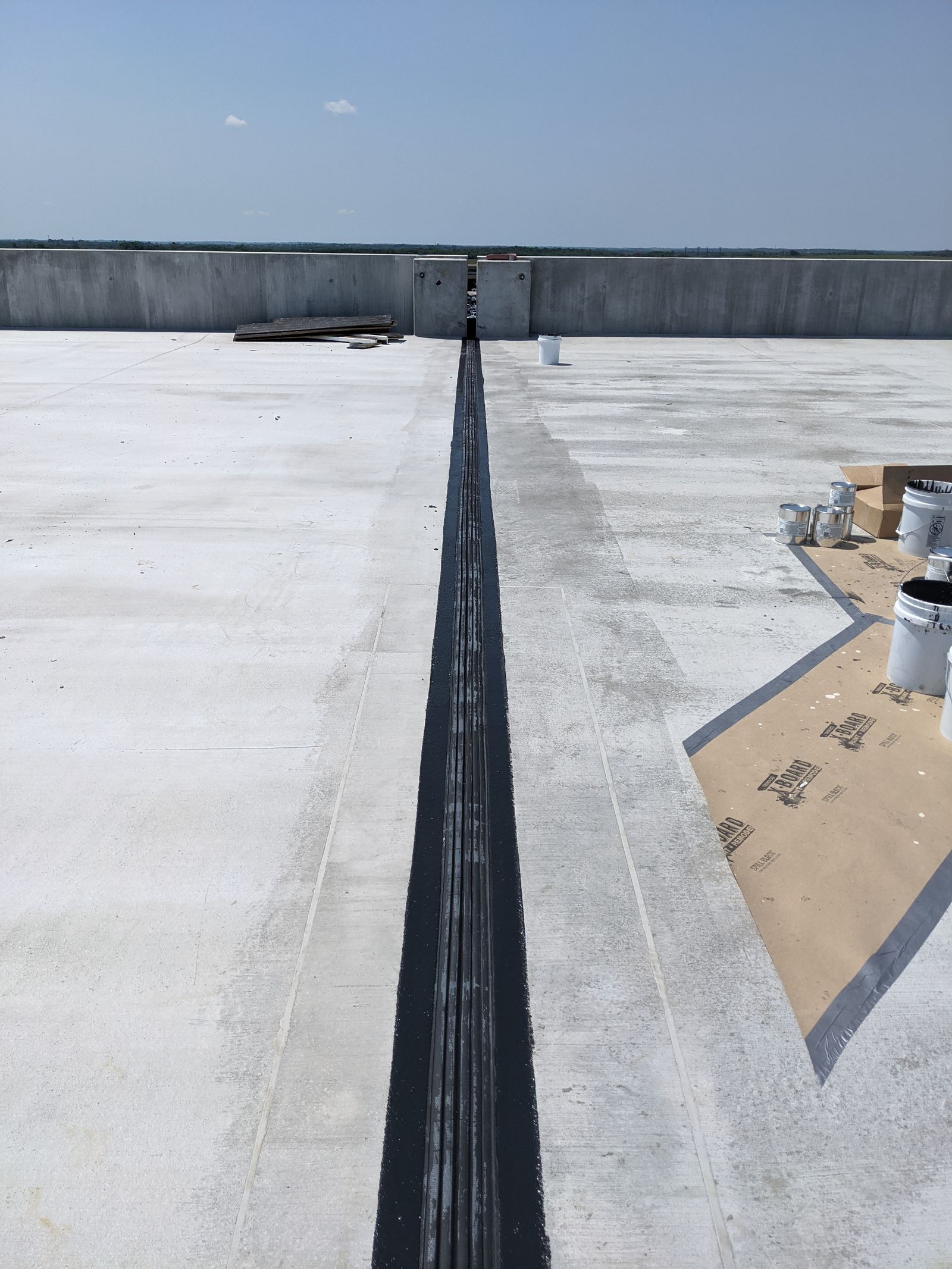 Winged expansion joint assembly installed in parking garage construction