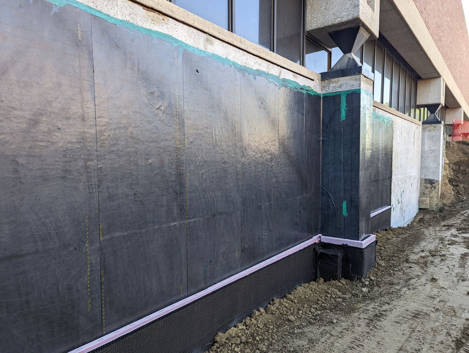 Self-adhering sheet waterproofing installed on a foundation wall